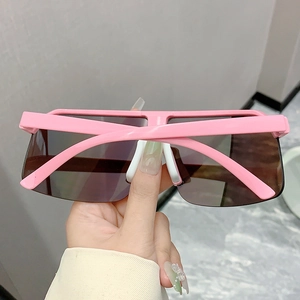 Detail of pink oversized cycling sunglasses with tinted lenses and white nose pads