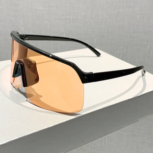 Detail view of large frame cycling sunglasses with orange lens and black semi-rimless frame