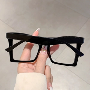 Detail of glossy black butterfly frame glasses showing premium material and wide lenses