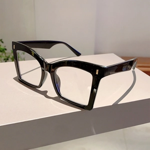 Detail of retro butterfly frame glasses with gold metal accents on a minimalist stand