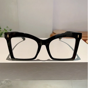 Detail of black butterfly frame glasses featuring stylish gold metal rivet accents