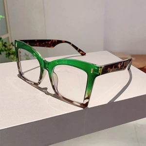 Detail of butterfly frame glasses featuring translucent green and tortoiseshell color block