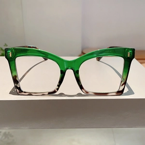 Detailed view of cat-eye glasses frame featuring two-tone green and tortoise shell finish