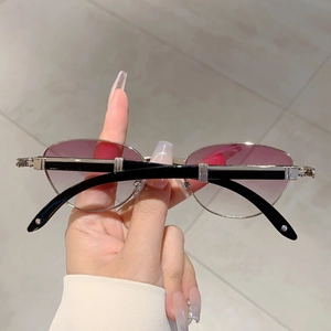 Close-up of vintage oval sunglasses with purple gradient lenses and silver metal frame