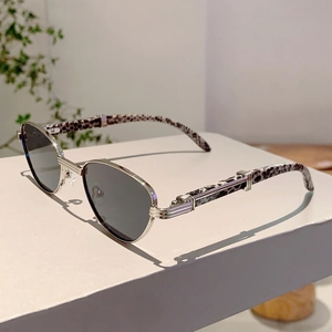 Close-up of silver metal sunglasses with leopard print temples on a white stand