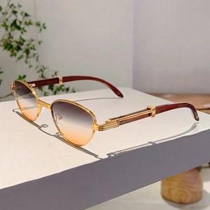 Detail view of gold metal frames with brown wood grain temples and gradient lenses