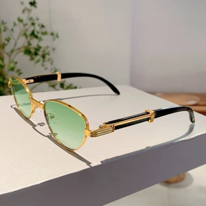Detail view of gold metal frames and green lenses on luxury vintage sunglasses