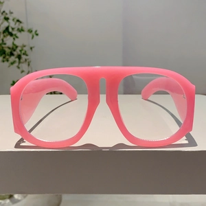 Gros plan sur la monture rose surdimensionnée montrant la texture plastique et le style rétro