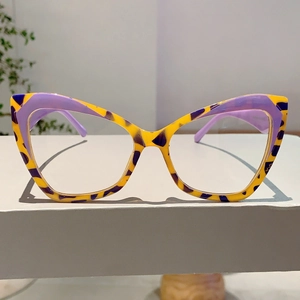 Detail of cat-eye glasses frame featuring bold yellow and purple tortoiseshell contrast