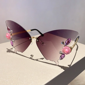 Detailansicht der schmetterlingsförmigen randlosen Sonnenbrille mit Perlen und Strasssteinen