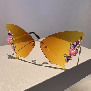 Details von schmetterlingsförmigen Sonnenbrillen mit gelben Gläsern und Strass-Akzenten