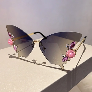 Nahaufnahme der Schmetterlings-Sonnenbrille mit rosa Blüten und Perlen auf weißem Sockel