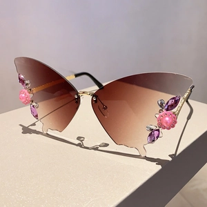 Detailansicht der Schmetterling-Sonnenbrille mit Strassblumen und goldenen Metallbügeln