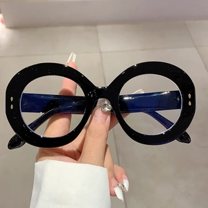 Macro shot of oversized round black glasses frame with detailed metal temple hinges