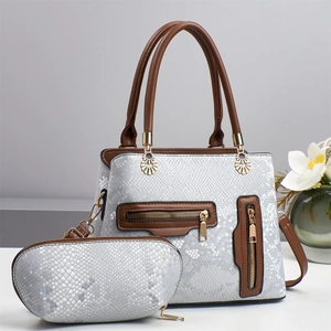 Detail of faux snake skin crossbody bag set with brown leather straps and gold hardware