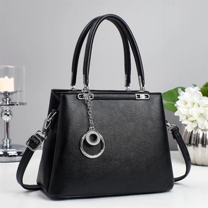 Detail of black pebbled leather tote with silver hardware and double ring pendant charm