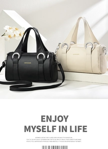 Close-up of Boston handbag in black and beige lychee leather with silver hardware details