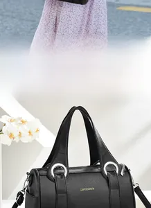 Detail of black Boston bag with pebbled leather texture and silver metal ring handles