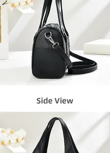 Side view of black pebble leather mini Boston bag with silver metal buckles and shoulder strap