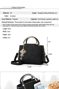 Detail of black pebbled PU leather handbag with golden ring handles and metal tassels