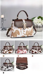 Detail view of cow print crossbody bag with dimensions 25x10x19cm and dual zippers