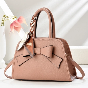 Detail of dusty rose litchi grain handbag with a silk scarf wrapped around handle