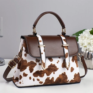 Stylish cow print crossbody handbag with brown leather accents and gold hardware decoration