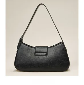 Detail view of the back of a black glossy crinkled leather underarm bag with a slim strap