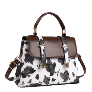 Stylish cow print crossbody bag with brown leather top handle and gold hardware