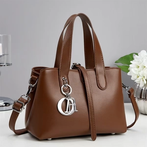 Brown leather tote bag with silver metal letter charms and adjustable shoulder strap