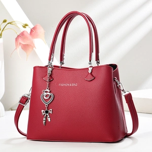 Sac fourre-tout rouge en cuir grainé avec pendentif cœur et bandoulière réglable