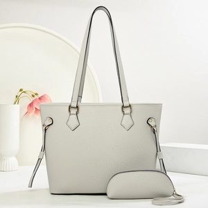 Detailed view of light gray lychee grain leather tote bag set with golden hardware