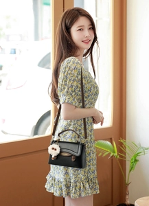 Détails du sac bandoulière vintage avec coutures ondulées et breloque boule peluche