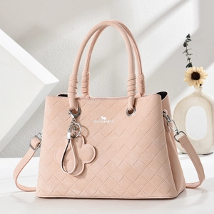 Elegant quilted pink shoulder bag with top handles and a clover charm accessory