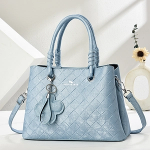 Detail of blue faux leather tote with woven texture and decorative spiral handles