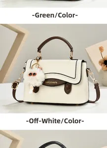Détail du sac à bandoulière blanc cassé avec poignée marron et breloque chat en peluche