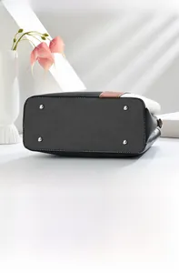 Detail of multi-color leather handbag bottom featuring four silver protective metal studs