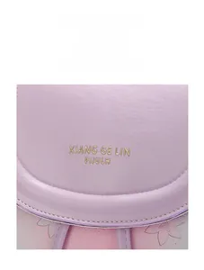 Macro detail of purple leather backpack flap with gold embossed logo and floral pattern