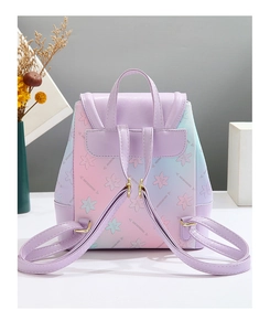 Close-up of rainbow gradient backpack with floral prints and pale gold metal hardware