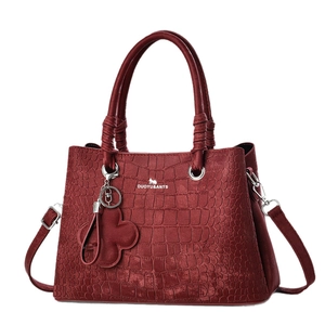 Deep red crocodile embossed women's handbag with shoulder strap and floral charm
