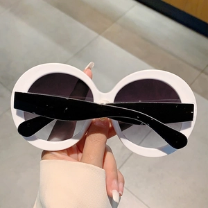 Close-up of white round sunglasses with thick frames and black lenses for a vintage look