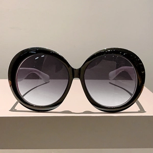 Macro shot of stylish round oversized sunglasses with black frame and gradient lenses