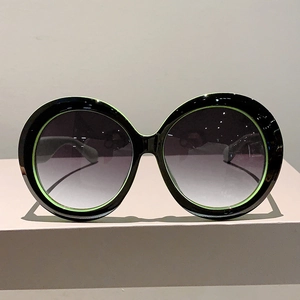 Oversized round sunglasses with black-green frame and purple gradient lenses