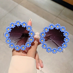 Detailed close-up of blue daisy flower frame on children's round resin sunglasses