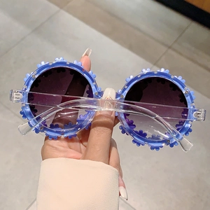 Close-up of kids flower round sunglasses with purple petals and clear resin temples