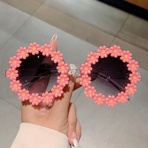 Close-up of pink daisy flower frame sunglasses with dark gradient lenses and clear temples