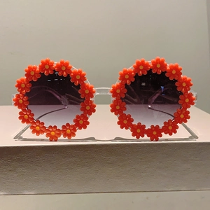 Detail of children's daisy sunglasses with orange flower frame for beach vacations