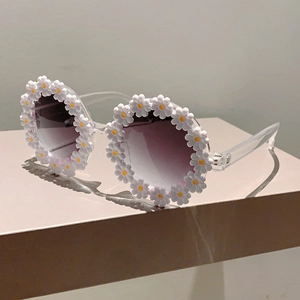 Detail of cute flower shaped kids sunglasses with white daisies and purple gradient lenses