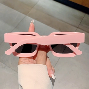 Gros plan de lunettes de soleil carrées roses avec monture épaisse et verres UV