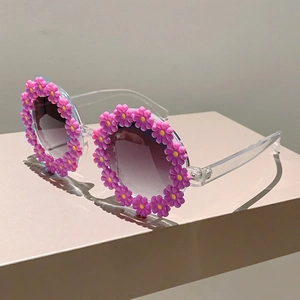 Detail of pink flower frame sunglasses for kids with grey gradient lenses for beach
